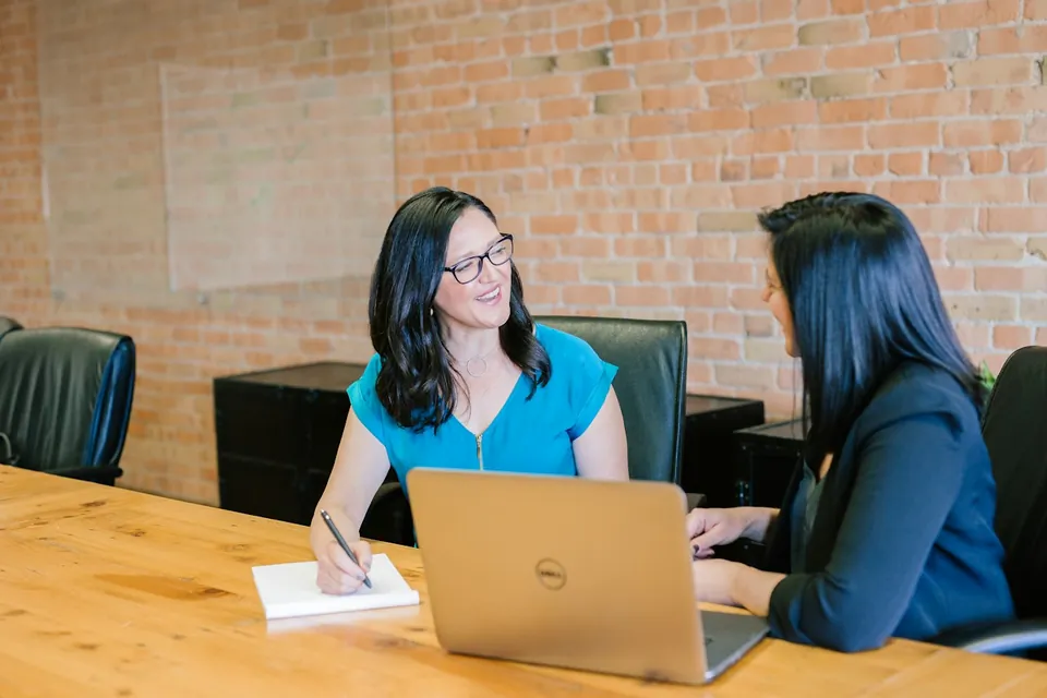 Colleagues discussing work together at a meeting table